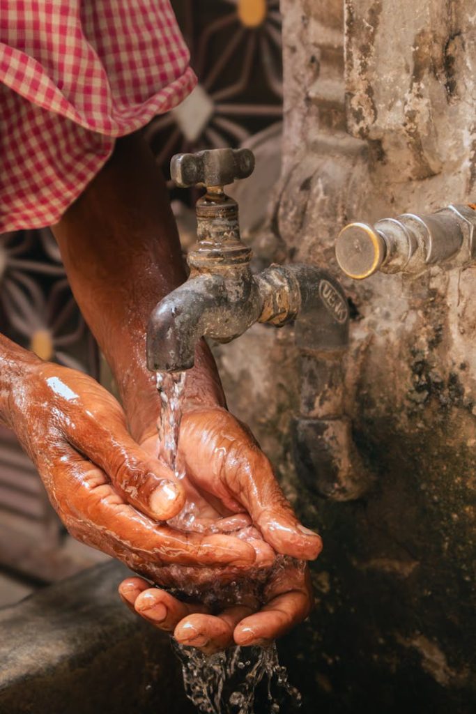 hands-washing-under-outdoor-tap-in-summer-28928634 Close-up of hands washing under an outdoor tap in a hot summer day, Jalandhar, India.
