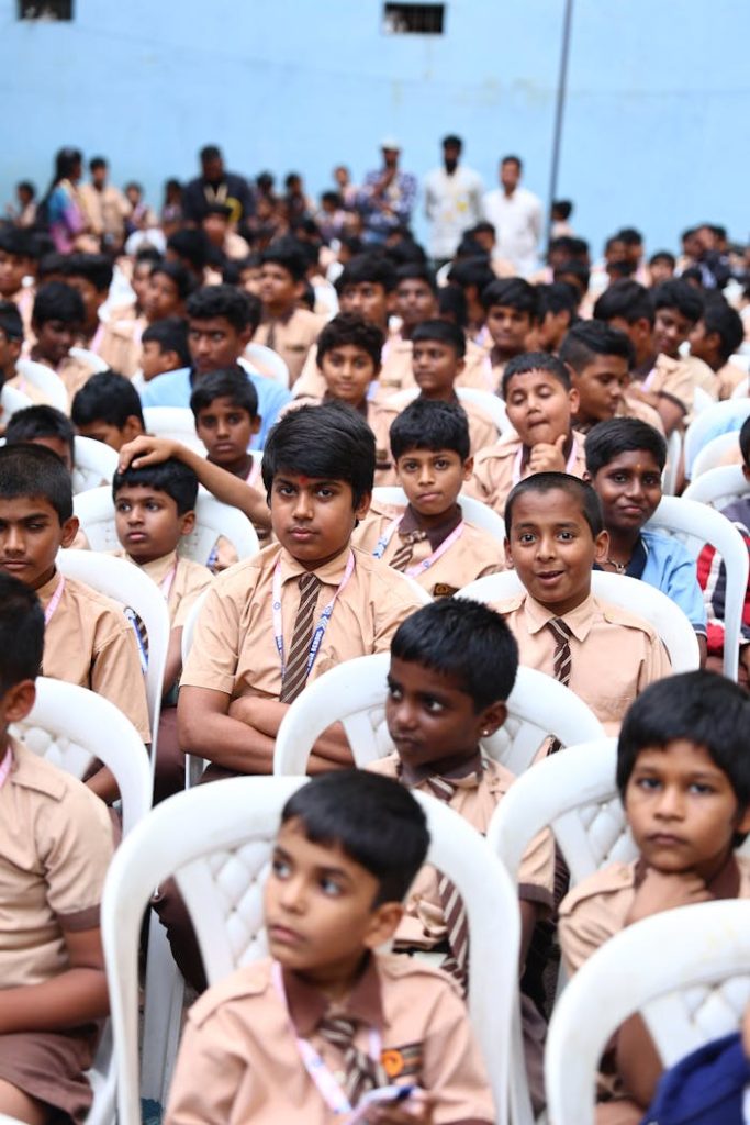 indian-school-boys-in-uniform-at-assembly-event-28389291 Indian school boys in uniform attending an outdoor school assembly event, seated in rows.